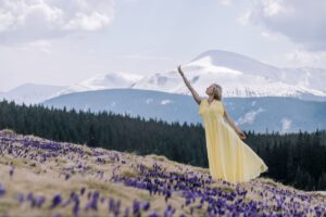 Весняні крокуси на полонині Кукул і учасниця в жовтій сукні на тлі сніжних вершин Чорногори