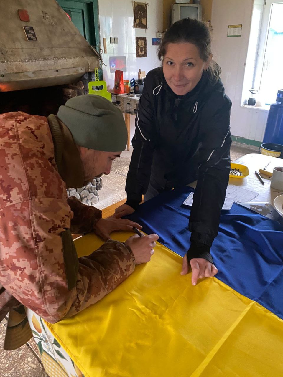 Підпис українського прапора учасником програми в затишній кімнаті гірського притулку